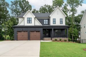 black home with two brown garage doors