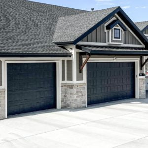 brick home with two blackish blue garage doors